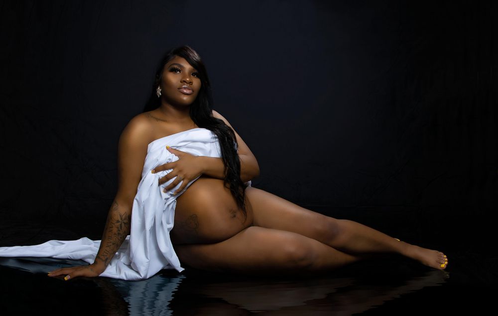 Maternity boudoir in dramatic, yet subtle lighting