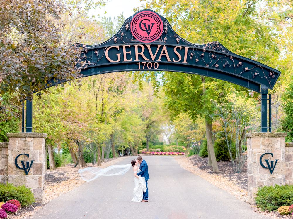Couple Kissing Under the Gervasi Vineyard Entrance Sign During Wedding at Gervasi Vineyard in Canton, Ohio