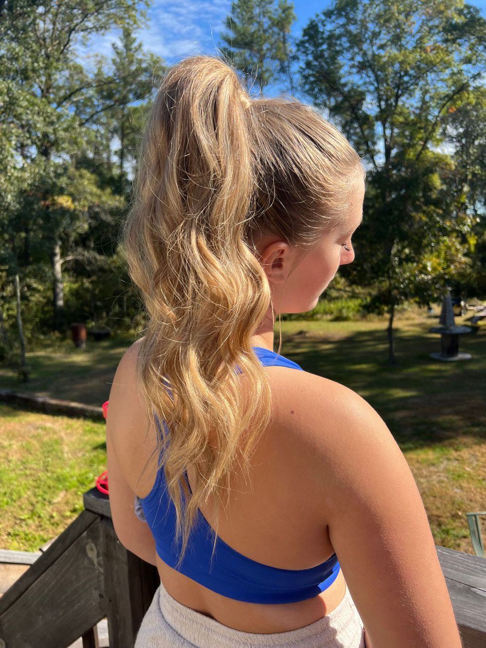 Outdoor hairstyle photos featuring a casual ponytail in bright blue athletic wear.