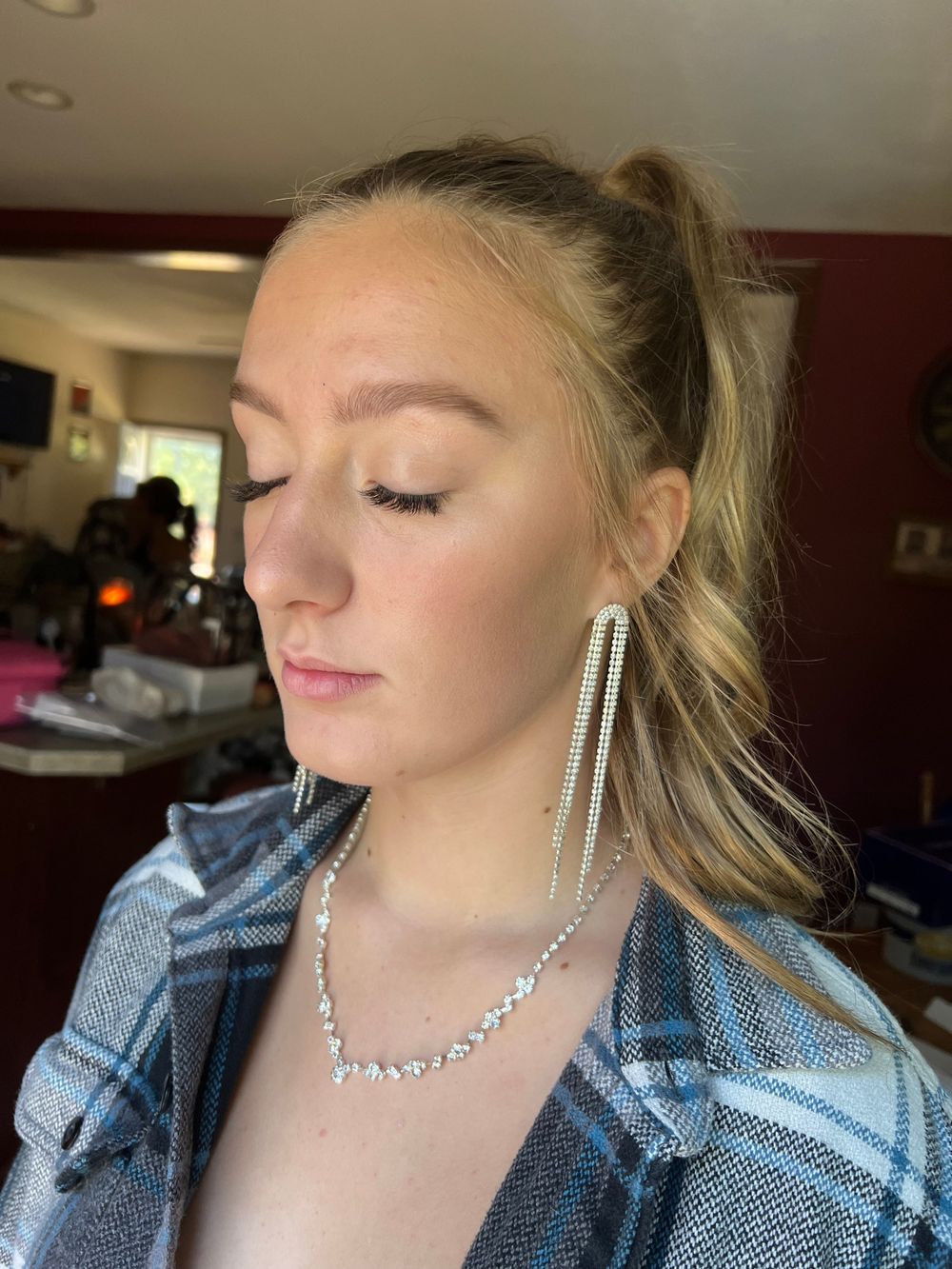 Side profile portraits showcasing sparkly jewelry and a denim jacket indoors.