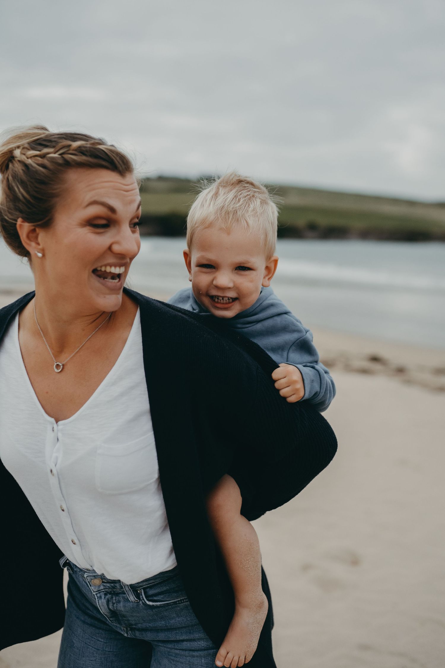A joyful moment shared between parent and child on a coastal beach.