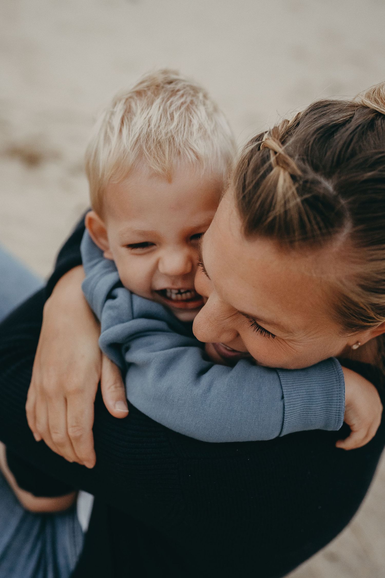 A heartwarming embrace shared between parent and child on the beach.