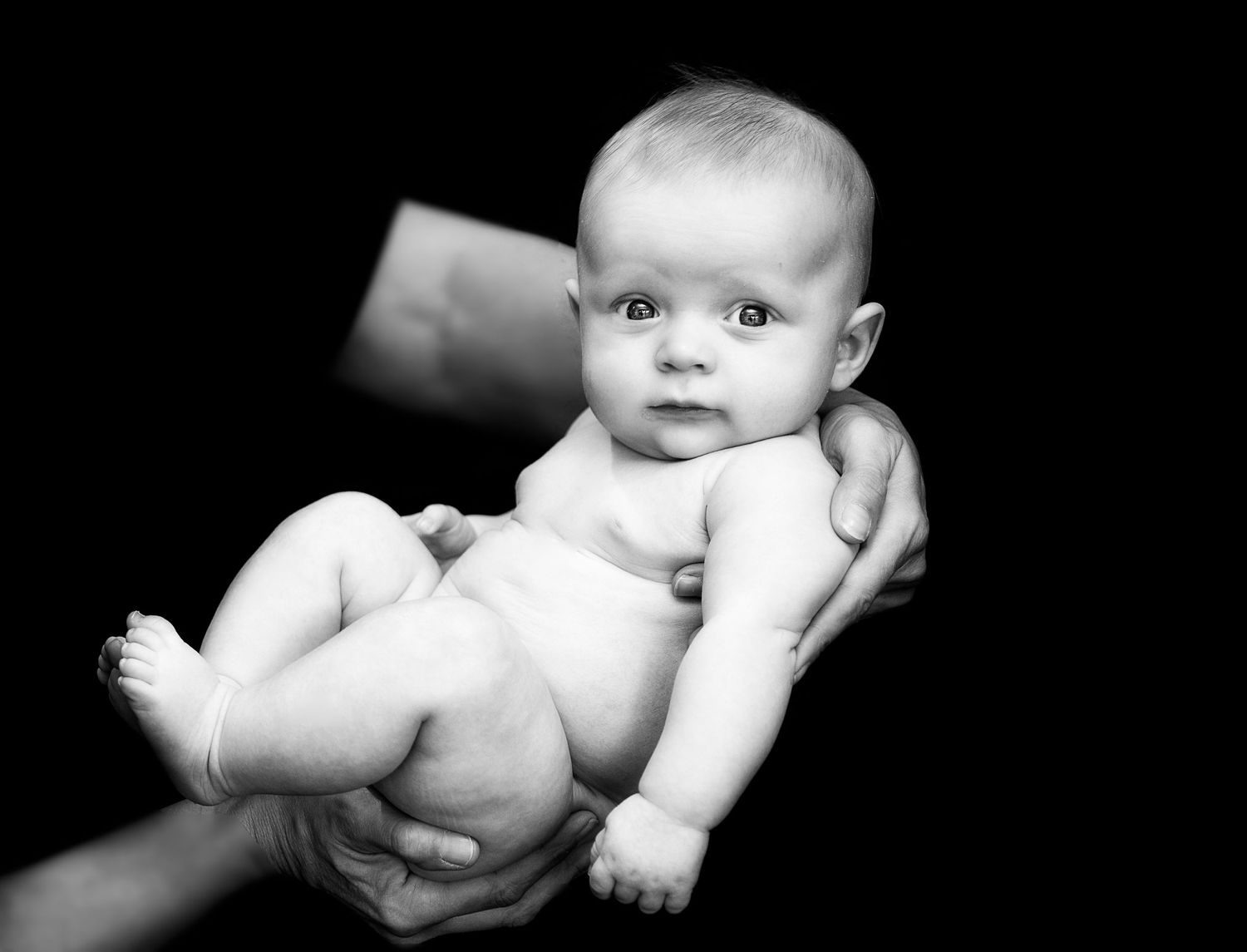 Black and white artistic photos of an infant with expressive poses.