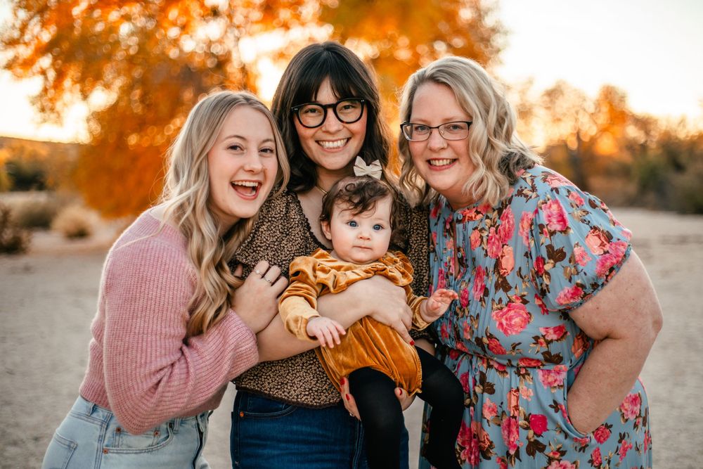 A group shares laughter during an autumn outdoor photoshoot.