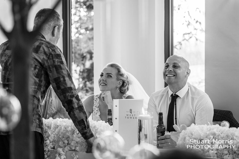 Bride and groom chat to wedding guests at the top table. West tower wedding photography. Lancashire wedding photographer