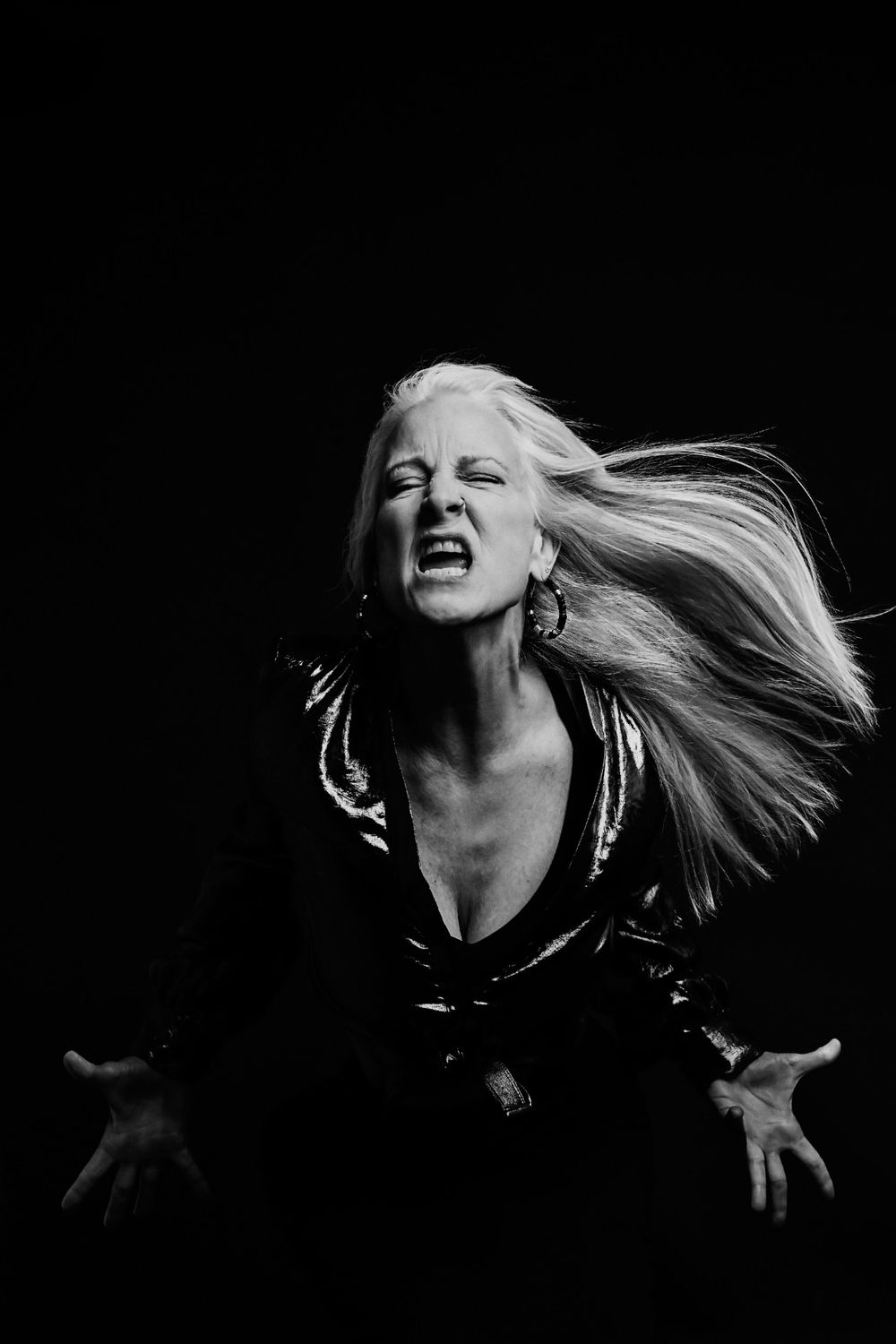 High contrast black and white portrait with dramatic hair movement.