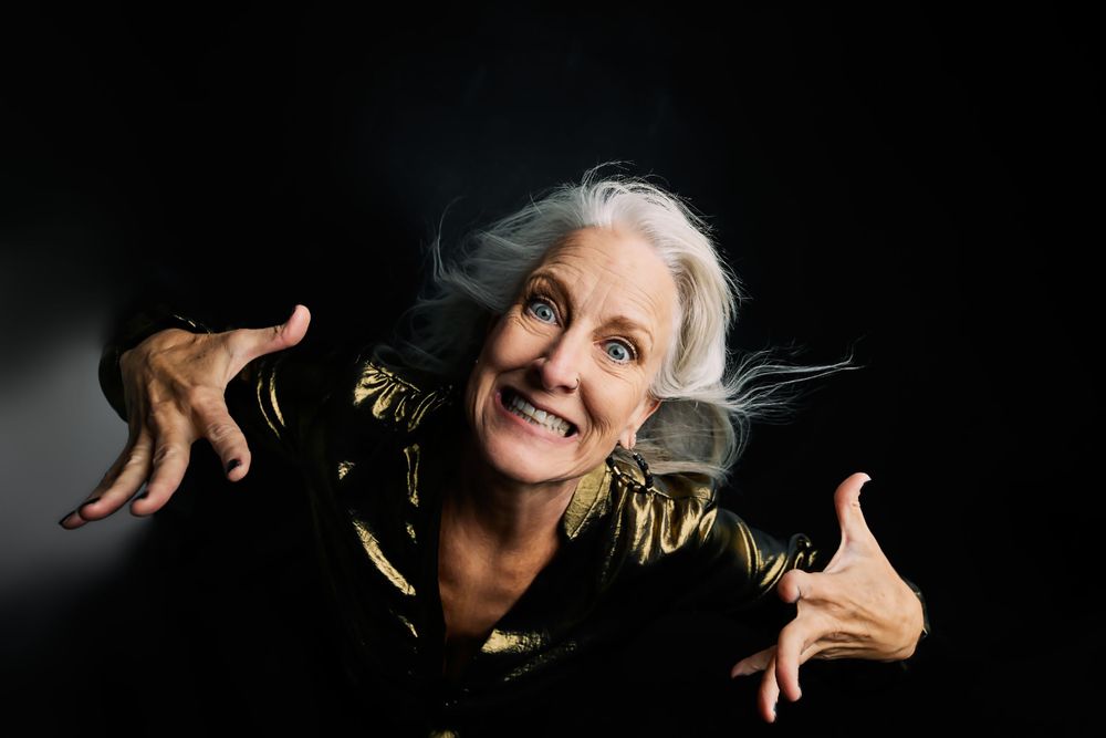 Joyful expression captured in dramatic lighting with flowing silver hair.