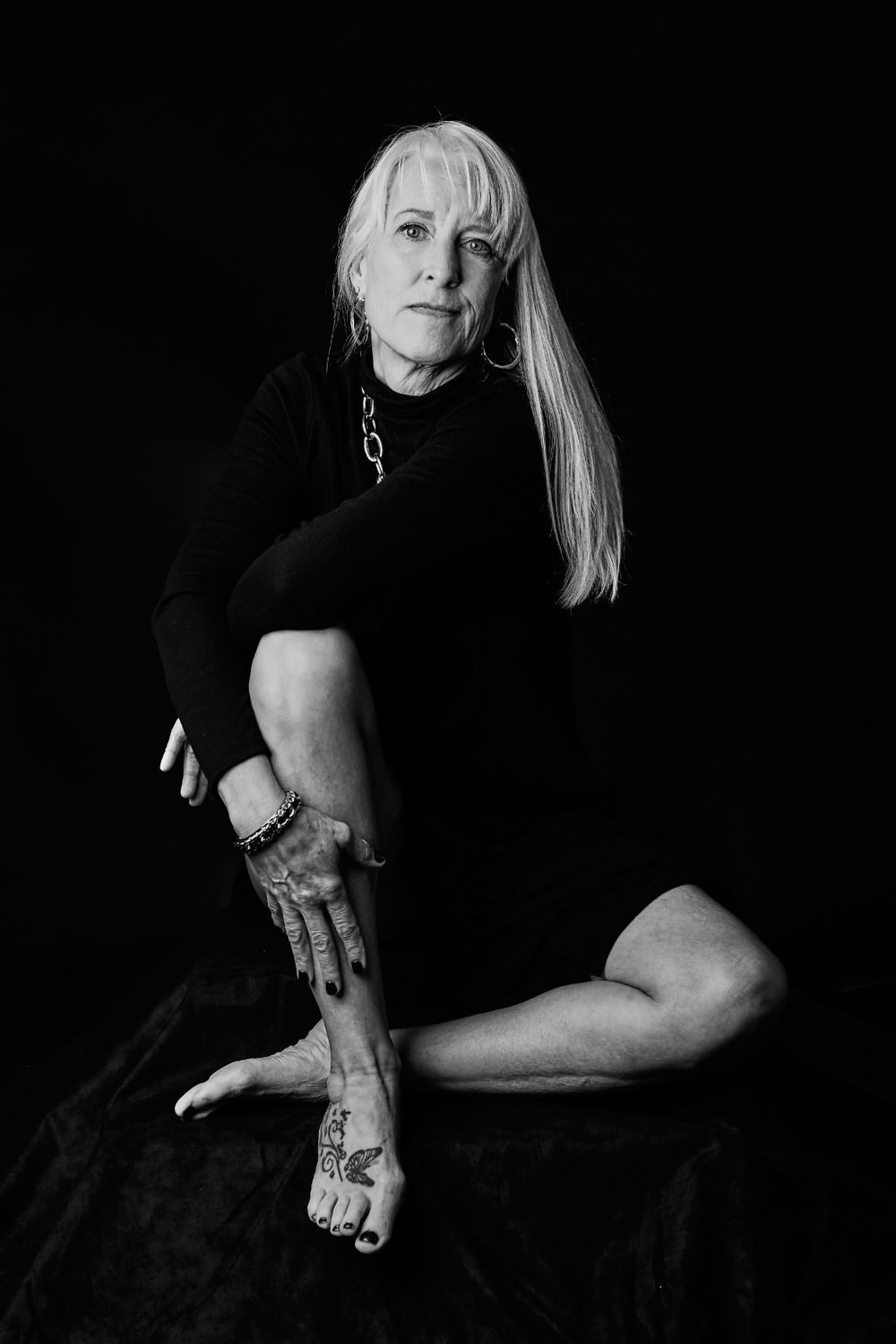 Artistic black and white portrait showing graceful movement in dark setting.