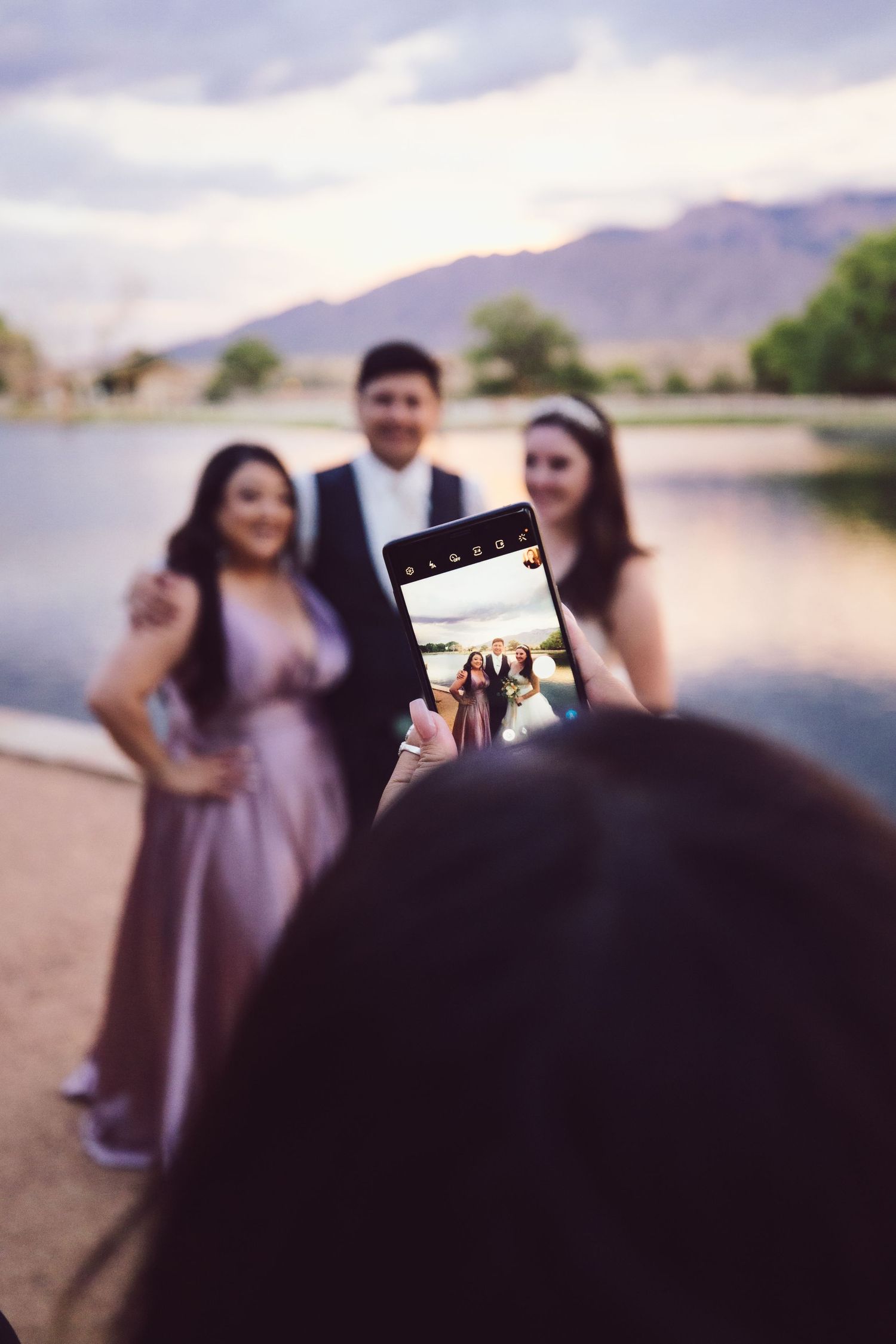 Guest taking a picture of couple with a cellphone