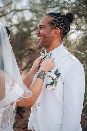 A close-up wedding portrait showing joy and laughter in a desert setting.