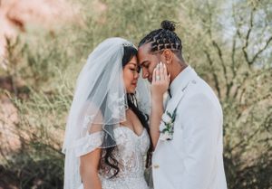 Artistic wedding photo capturing intimate moment between bride and groom against soft background.