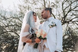 A romantic portrait of newlyweds in white against a natural background.
