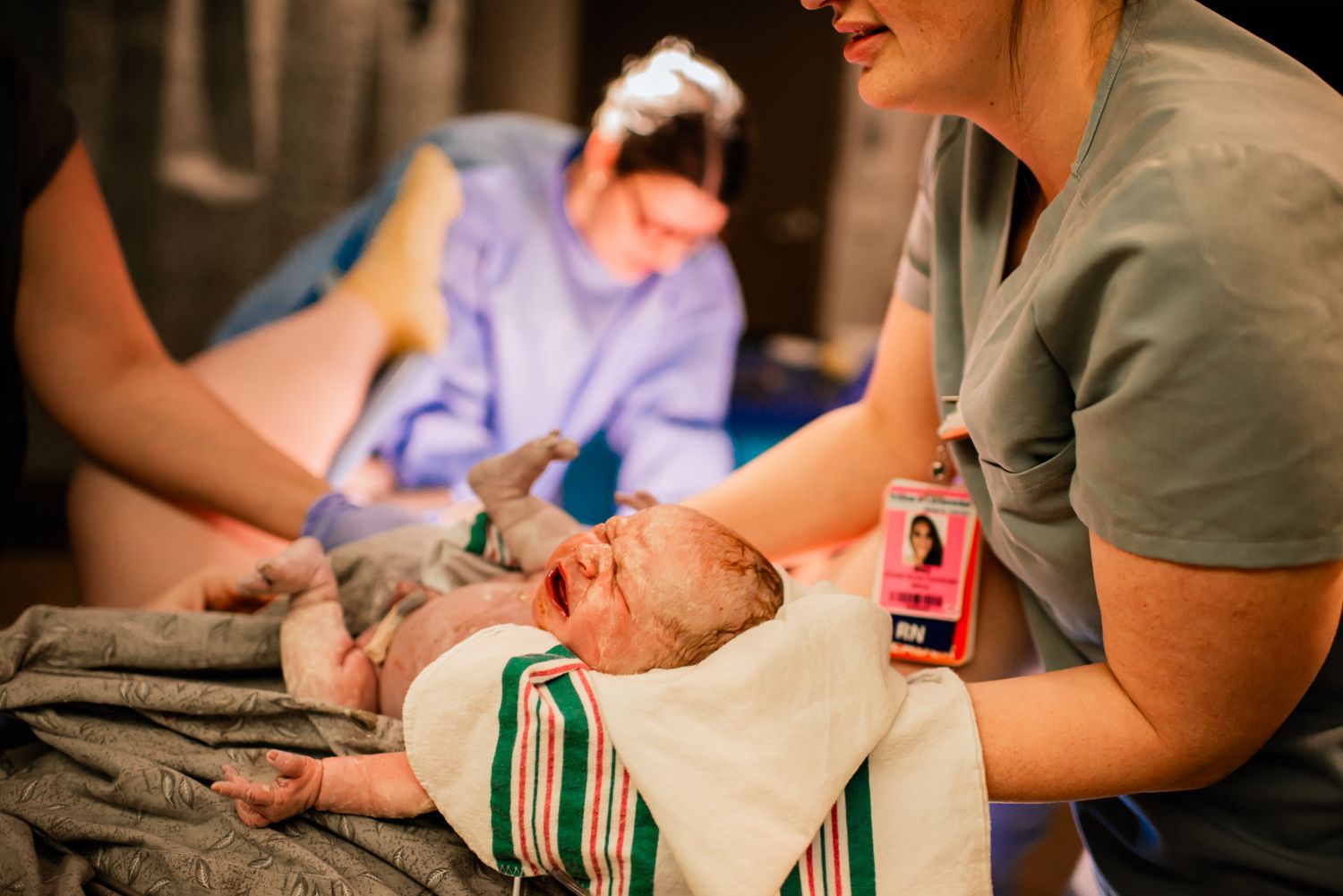 Medical staff caring for a newborn baby in a clinical setting.