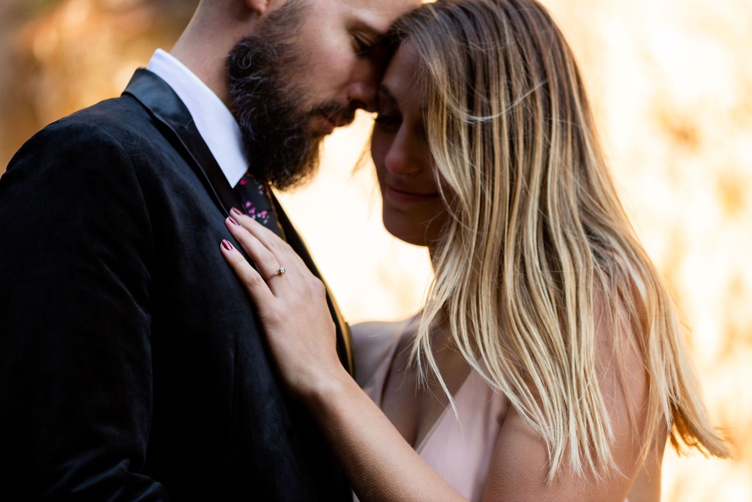 Intimate close-up engagement portrait with soft golden lighting and romantic atmosphere.