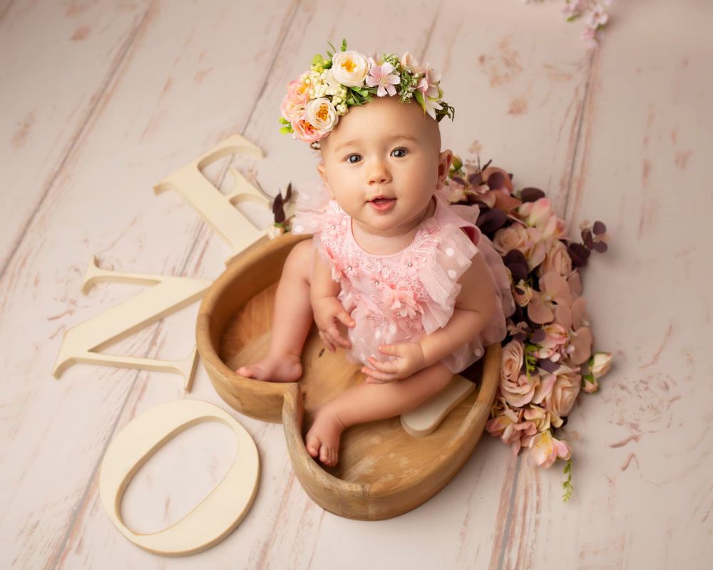 girl child first birthday celebration photo in a heart prop