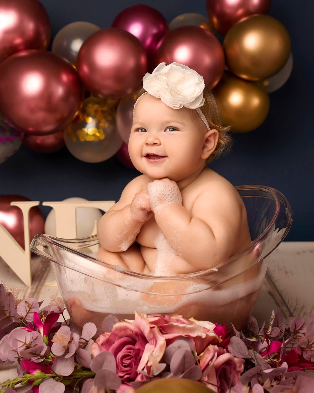 first baby girl birthday splash in a tub portrait photo