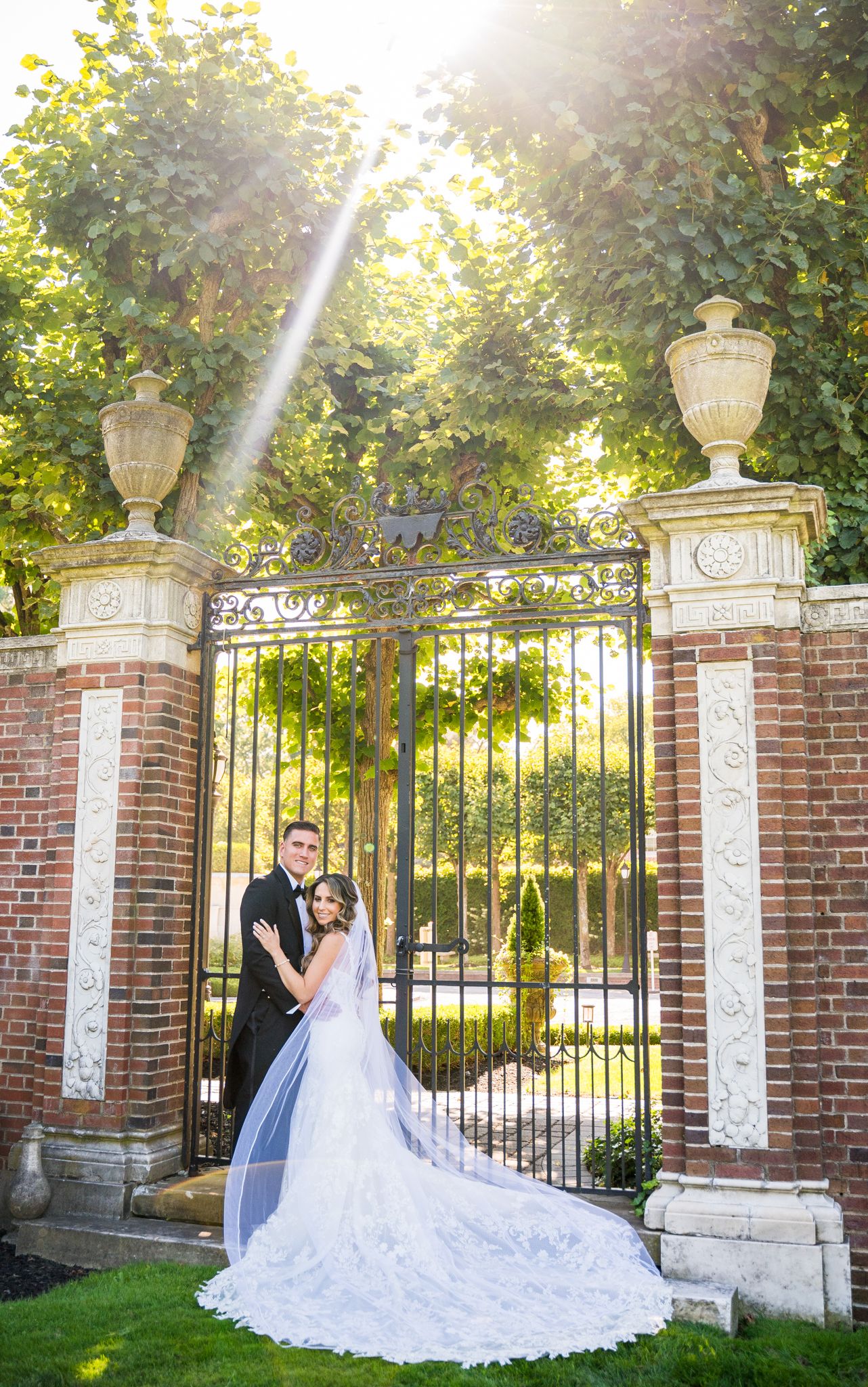 Couple posing in front of an elegant entrance on their wedding day.