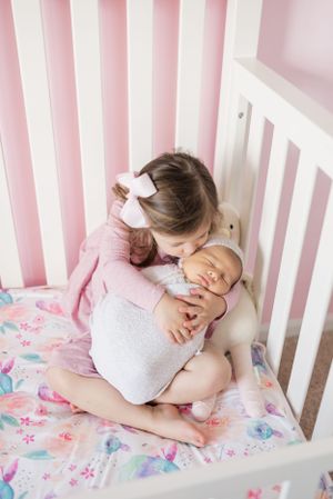 sister cuddling new baby brother