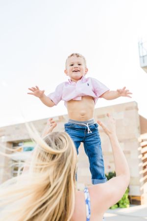 mom throwing boy up in the air smiling