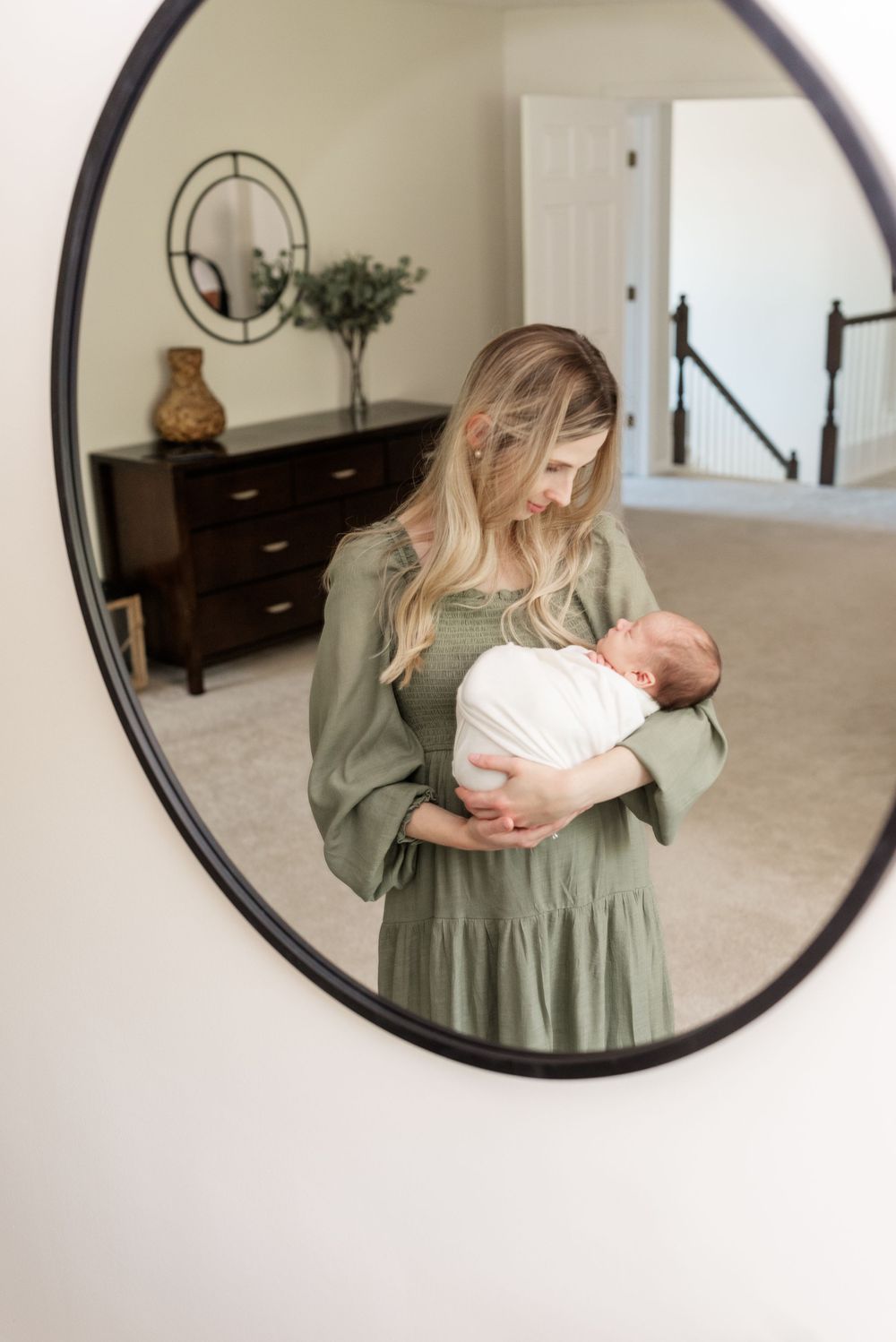 mother holding newborn baby wrapped