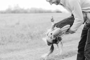 dad tipping daughter upside down