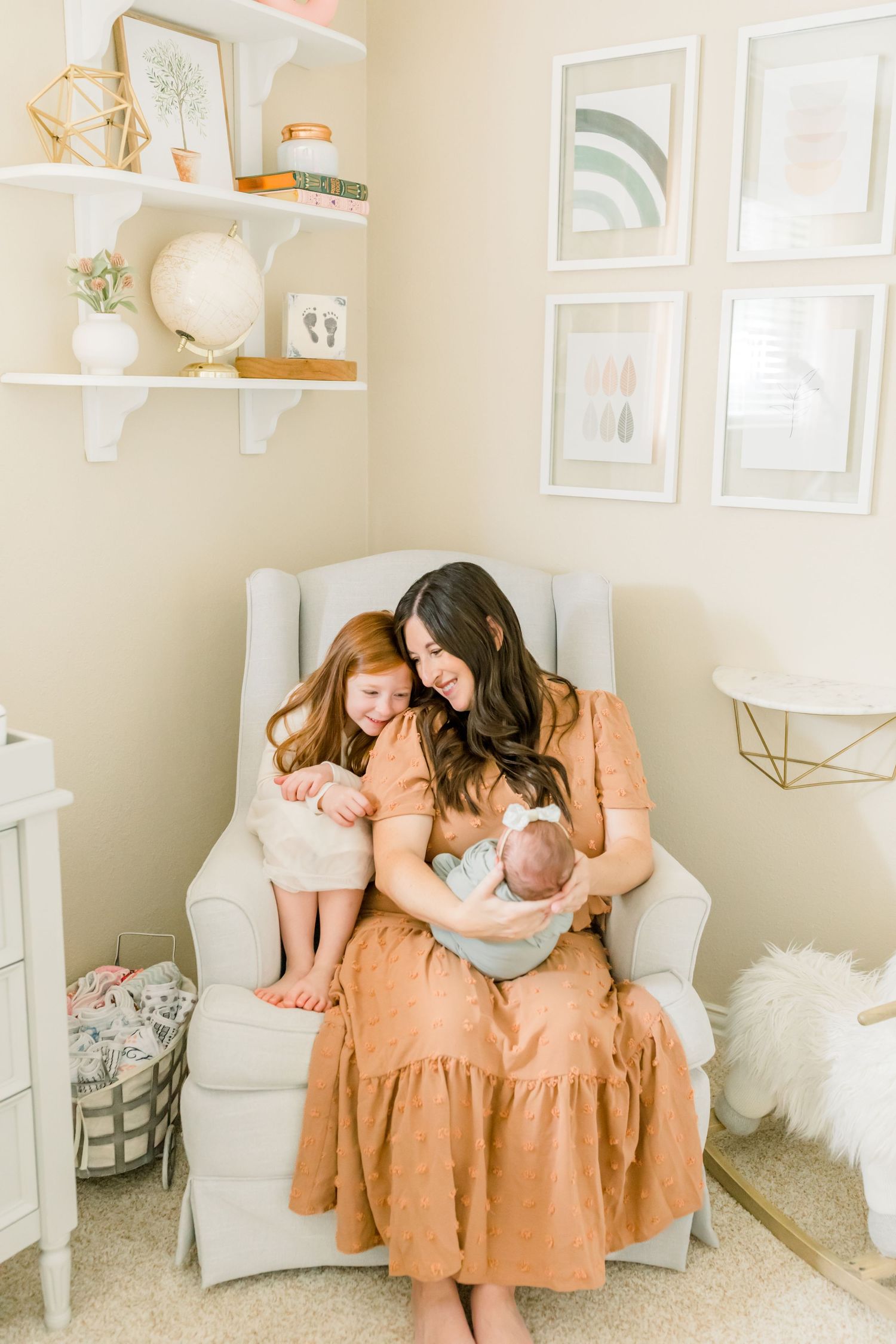 Family gathered in a peaceful nursery with modern decor and white accents.