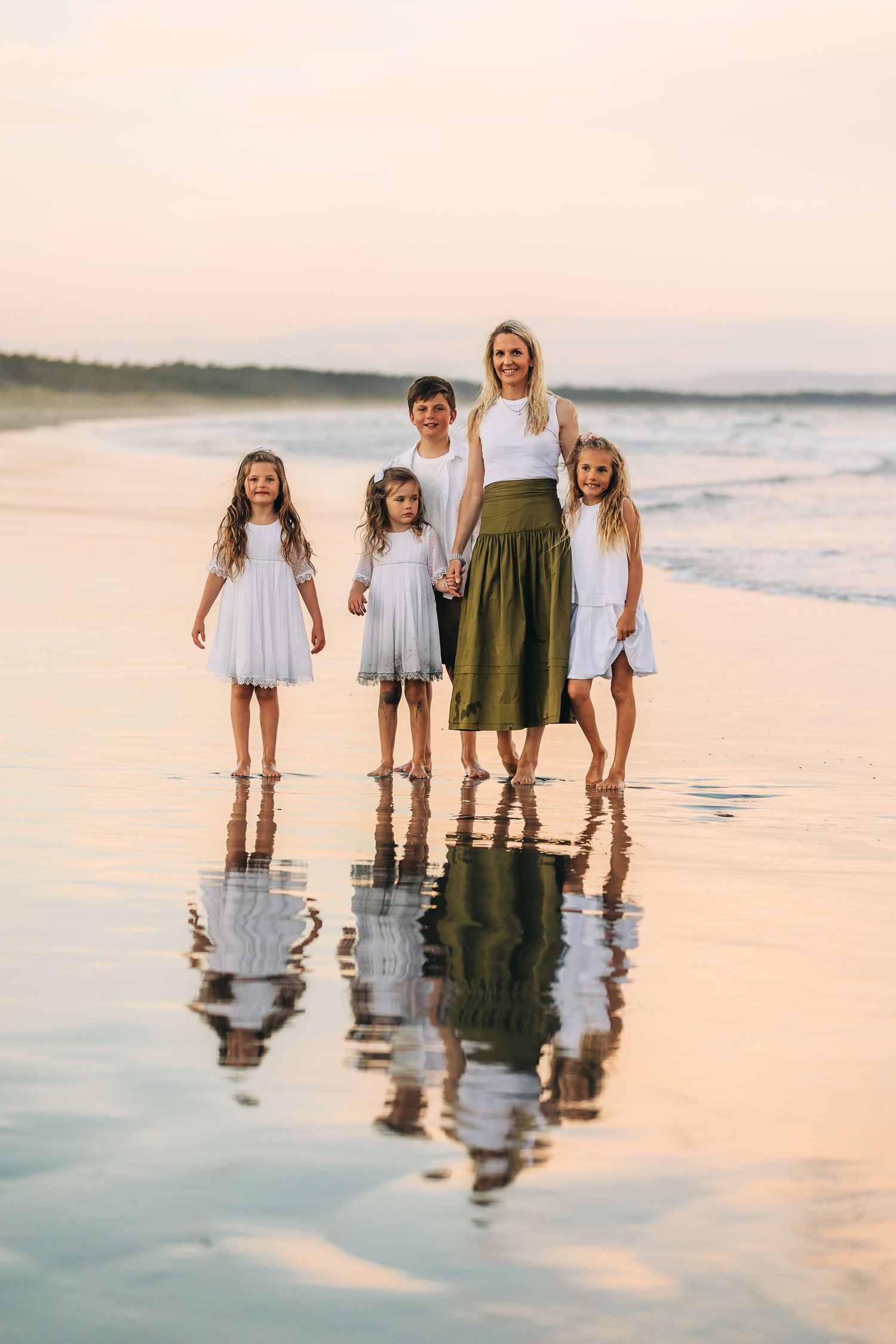family on beach at sunset with reflections in christchurch