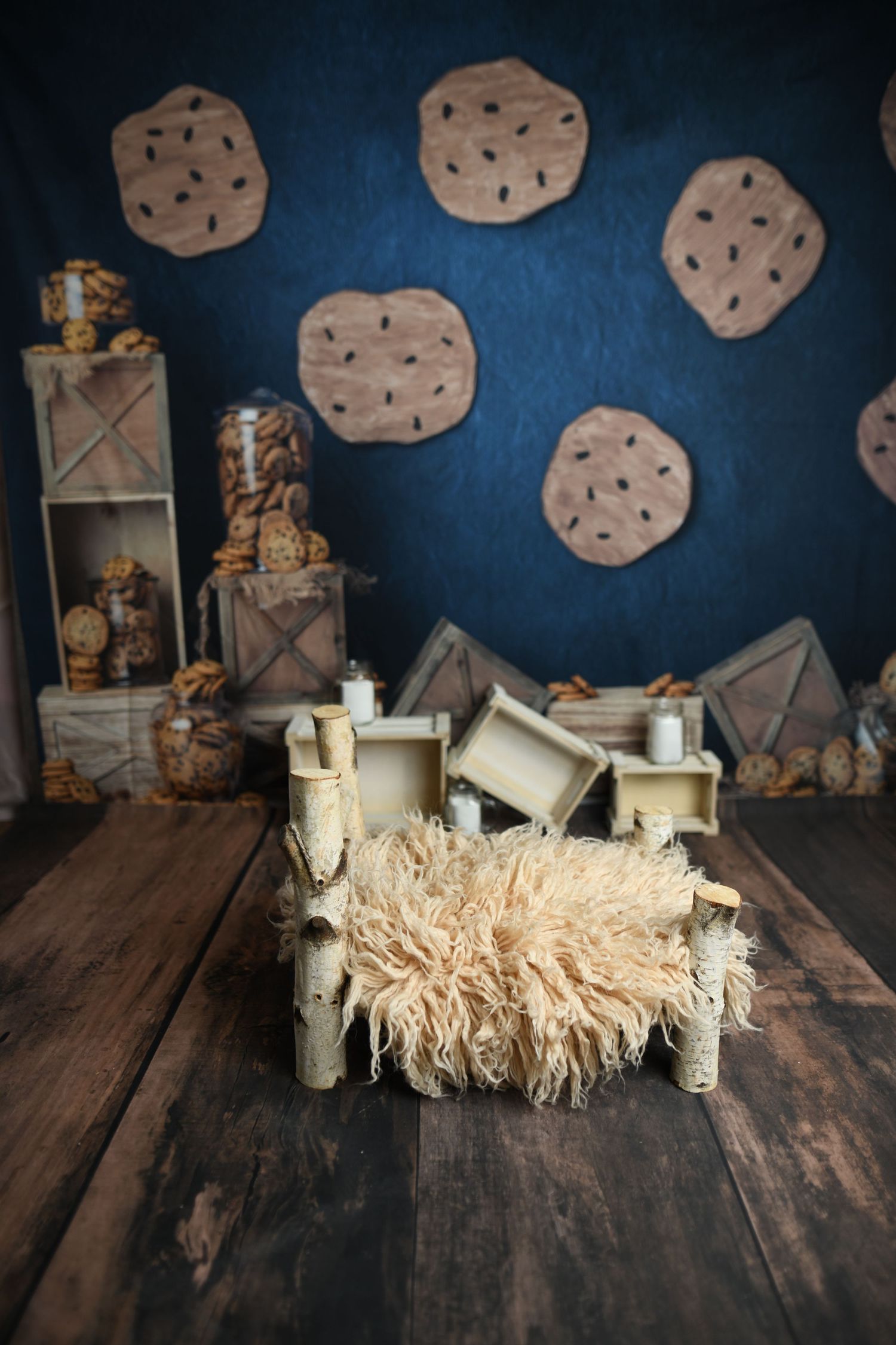 Rustic wooden backdrop with cookie decorations and textured boxes against deep blue wall.