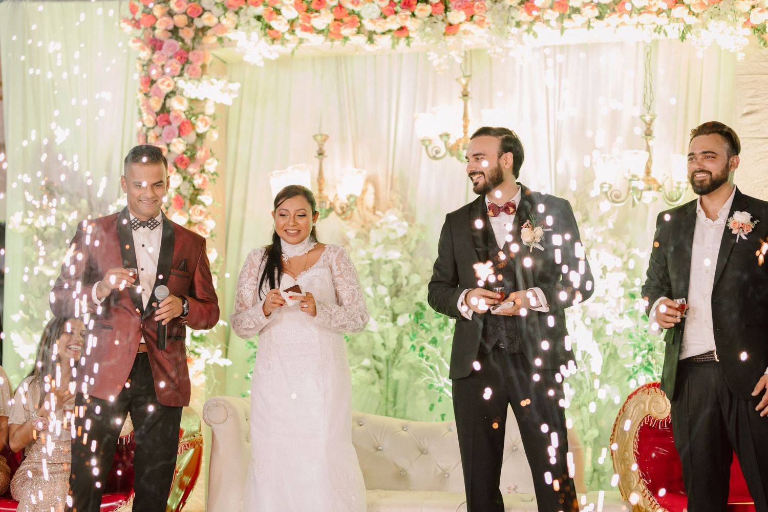 Joyful celebration with confetti falling during a wedding reception in an elegant indoor venue.