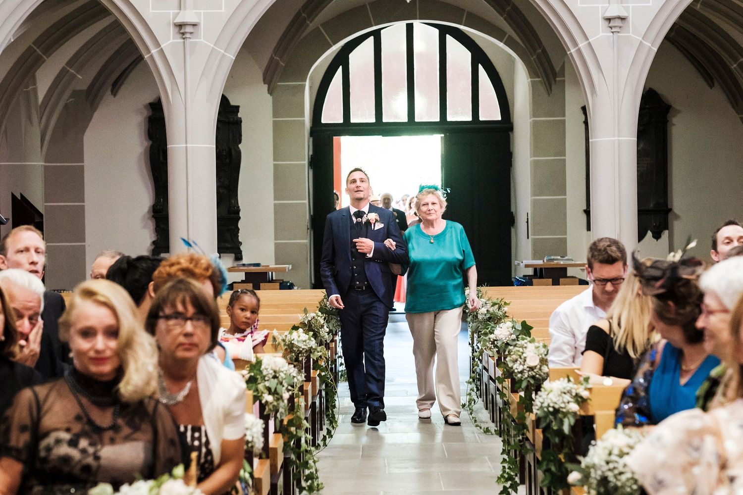 TLOOK photographe de mariage de style documentaire, cérémonie religieuse à l'église de vevey le marié entre avec sa maman