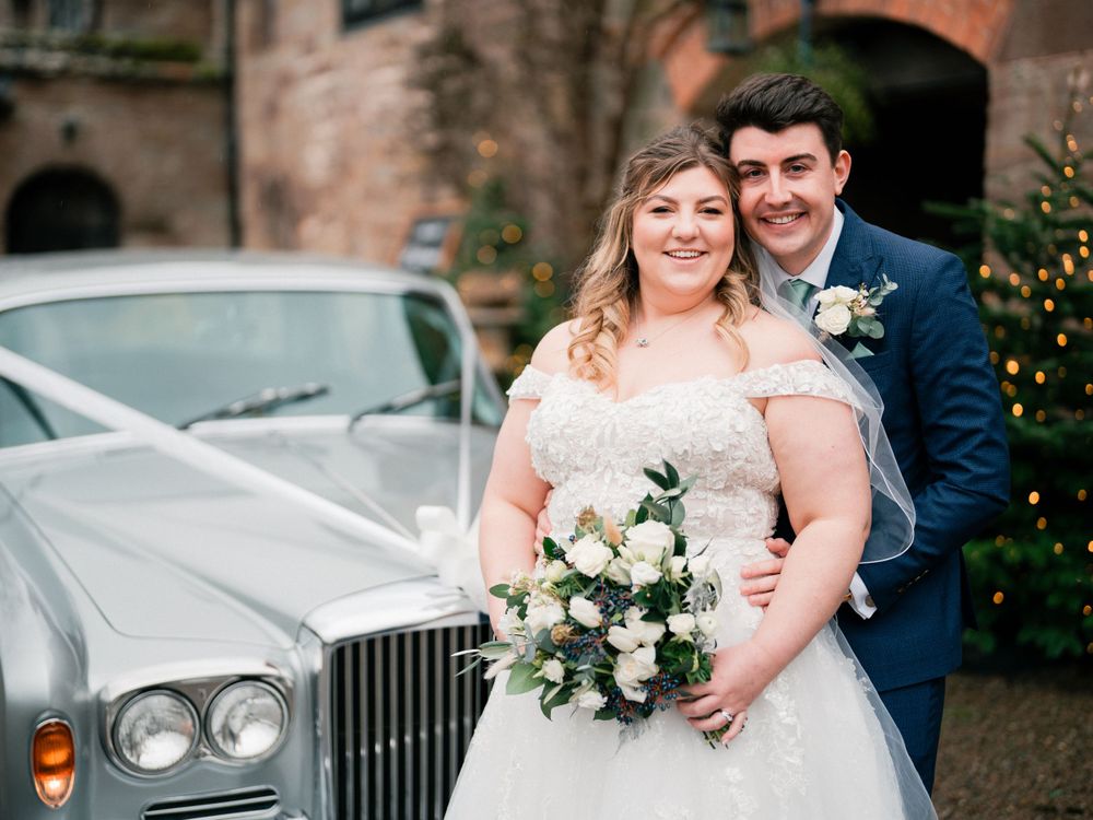 Elegant wedding portraits with vintage Rolls Royce car in background.