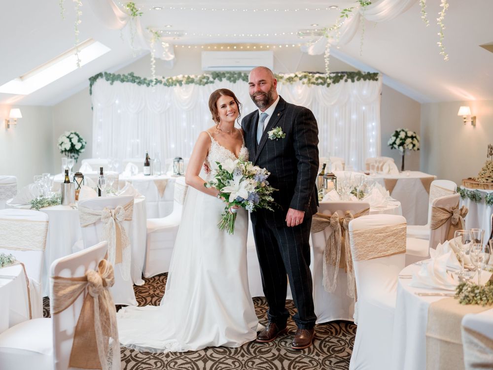 Elegant wedding reception setup with white decor and string lights creating romantic ambiance.