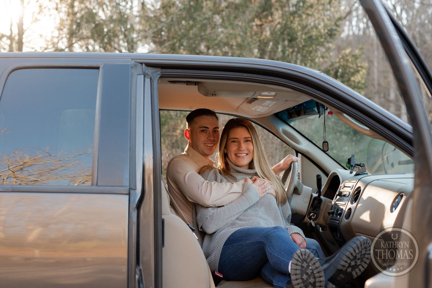 Happy couple sitting in truck cabin sharing a playful moment together.