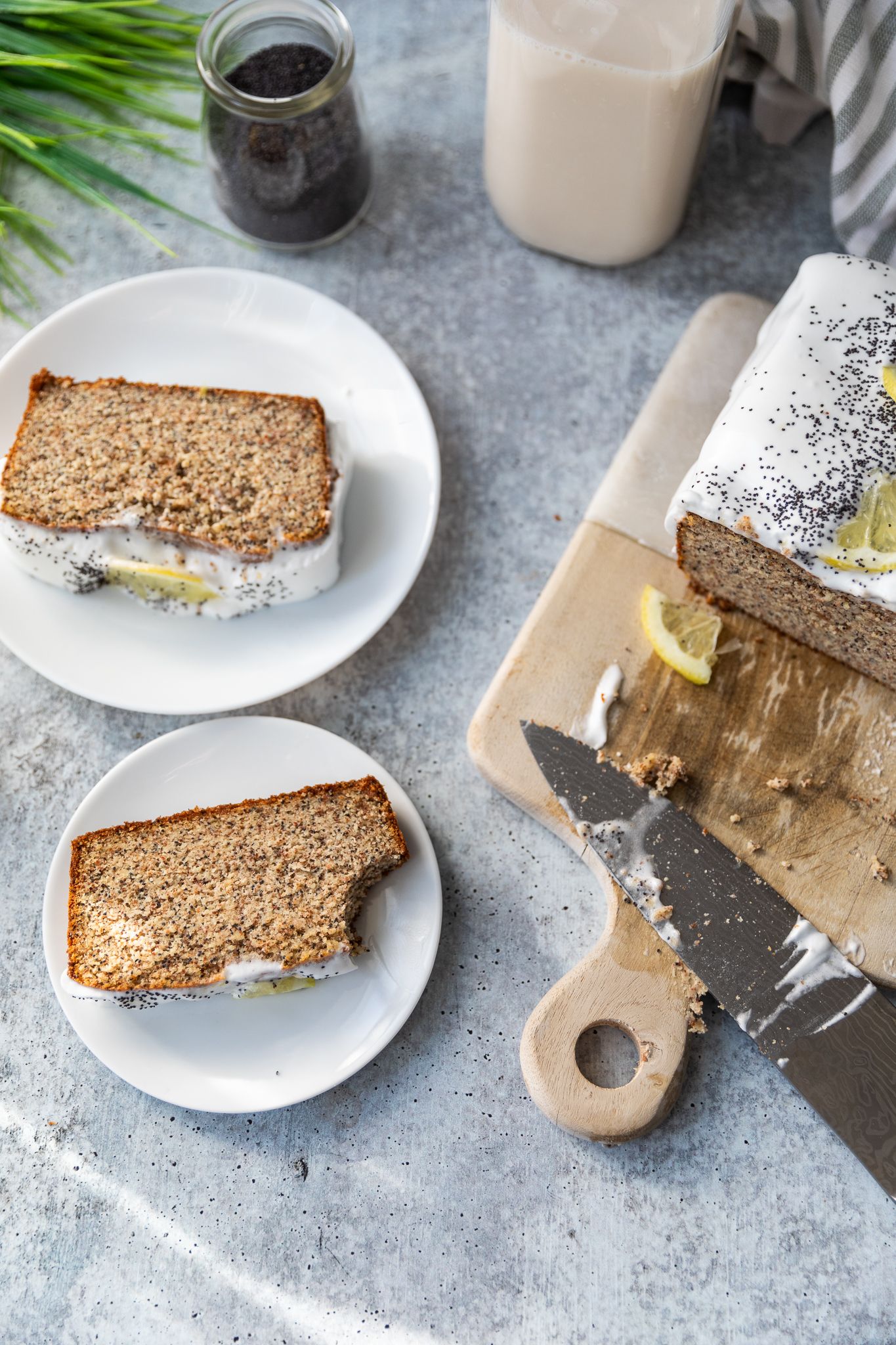 Slices of whole grain bread with butter on white plates against a gray background.