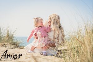 Beach portrait with sand dunes and sea grass in soft natural lighting.