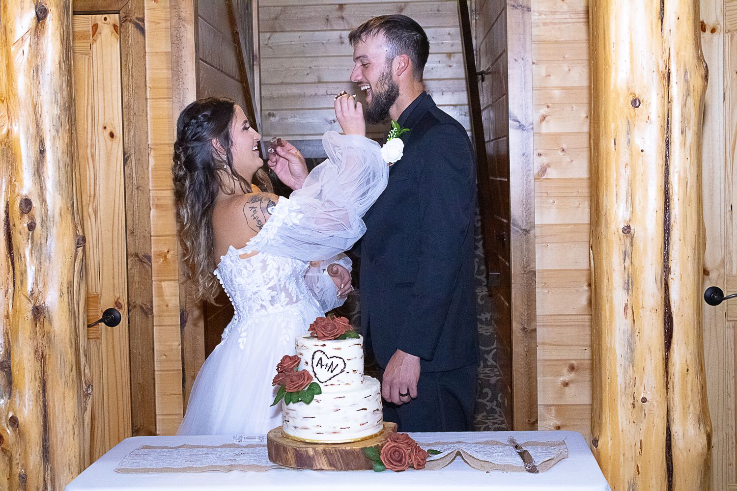 Wedding couple sharing intimate moment in rustic wooden cabin setting.