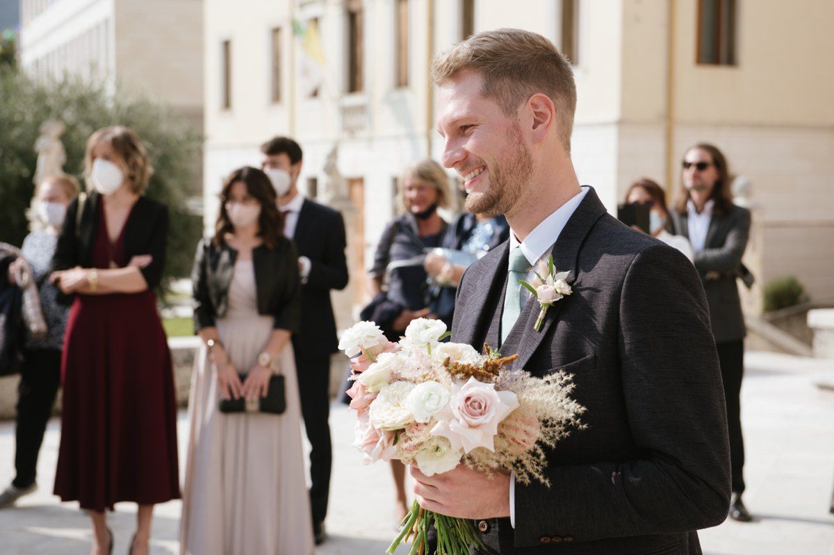 Joyful wedding moment captured outdoors with floral bouquet.