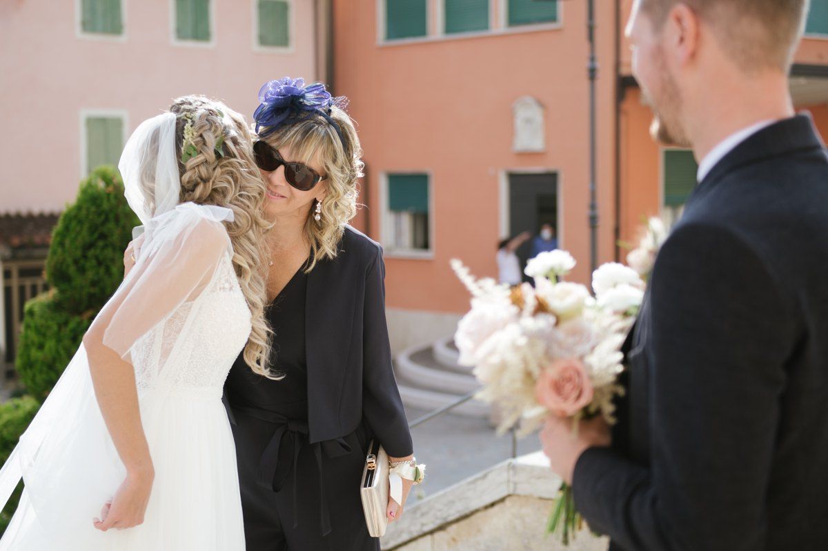 Intimate outdoor wedding ceremony moment in front of pastel buildings.