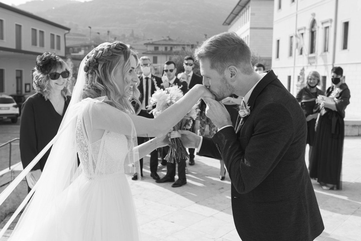 A traditional wedding ceremony moment captured in black and white on a European street.