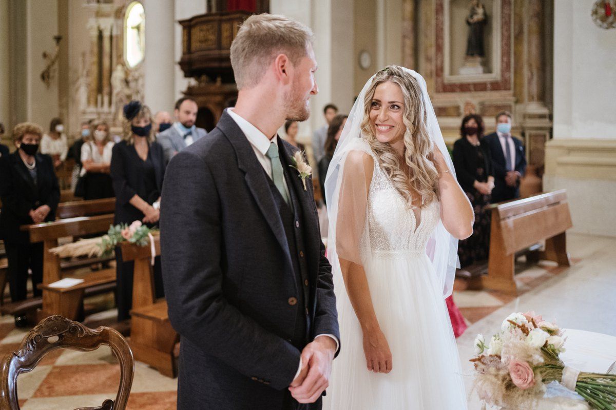 A wedding ceremony taking place in an elegant church interior with classic architecture.