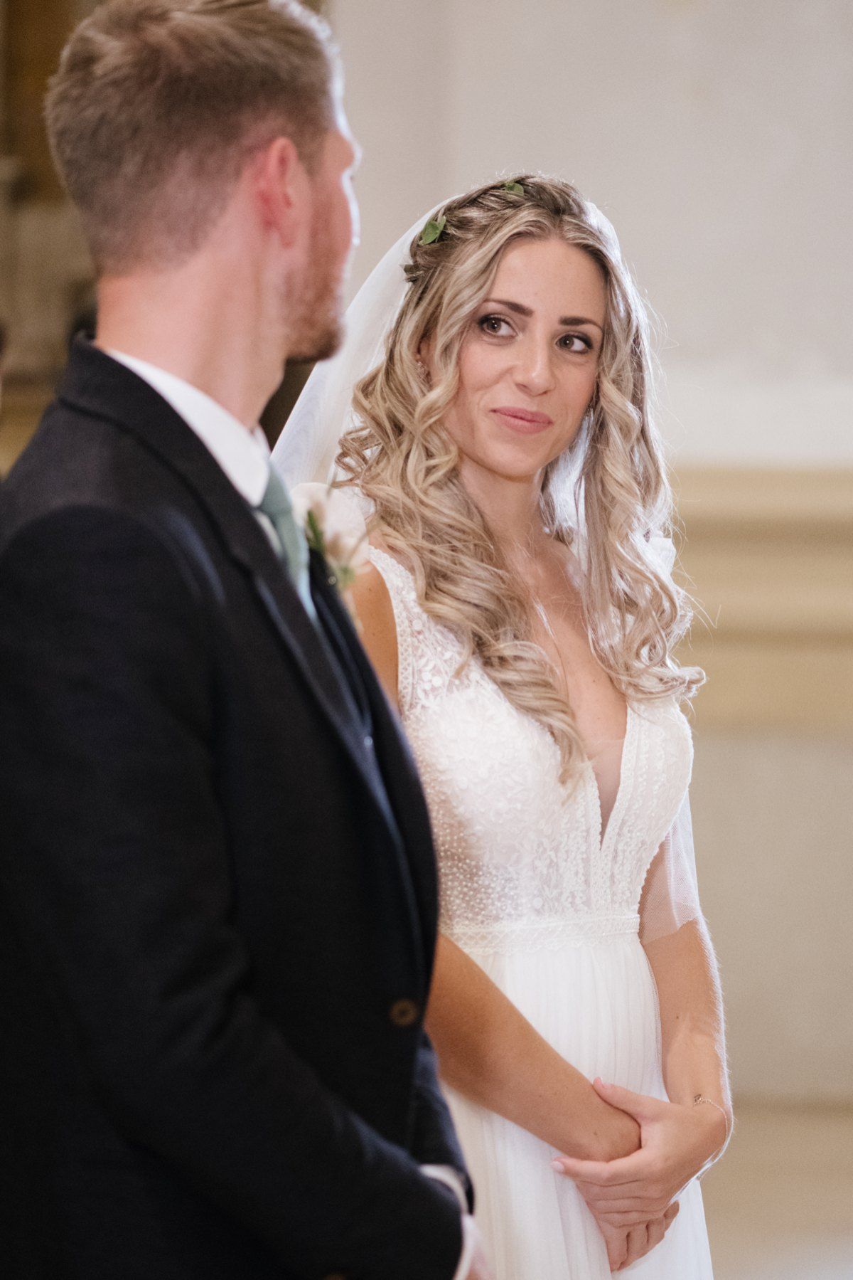 An intimate wedding moment captured inside a historic church with white stone walls.
