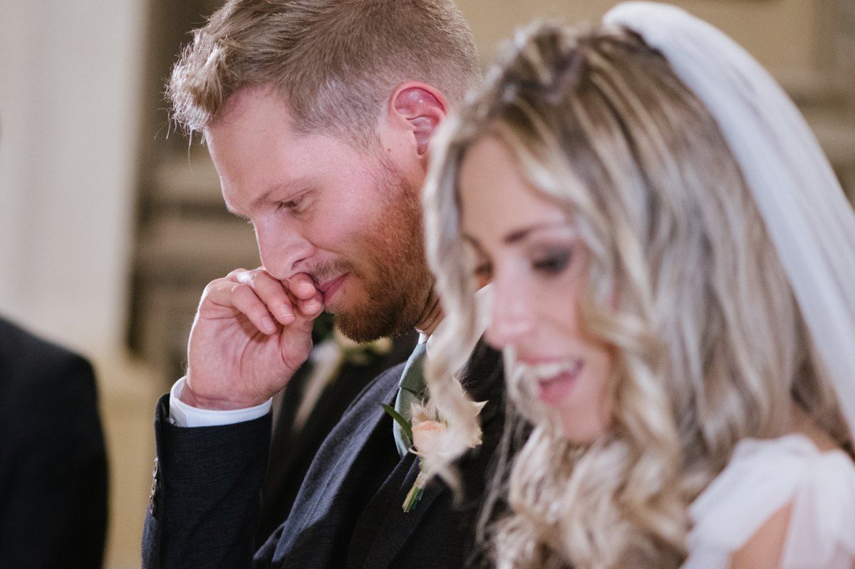An emotional moment captured during a wedding ceremony in an elegant church setting.
