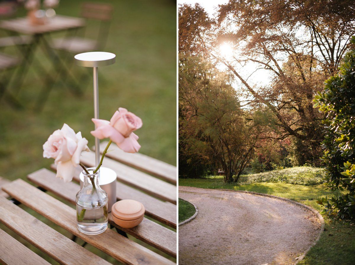 Delicate pink roses in vase beside winding garden path at sunset.