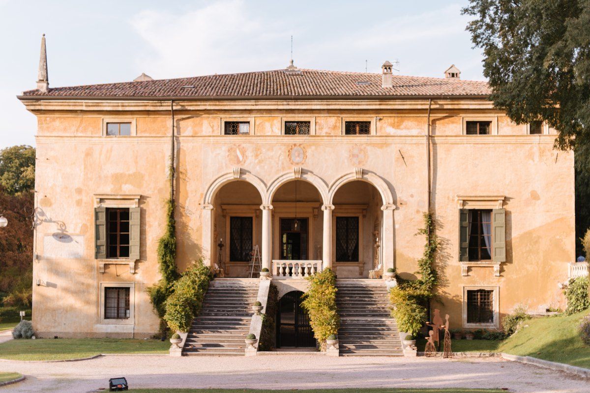 Italian villa with arched colonnade and peach-colored facade in classic Renaissance style.