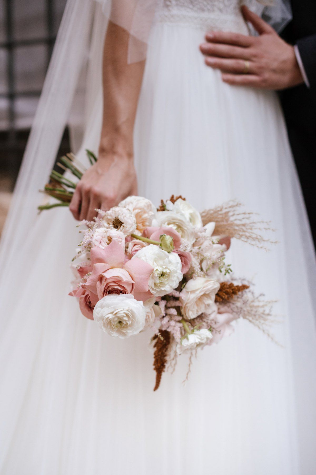 Elegant bridal bouquet with pink and white roses, dried flowers and textural elements.