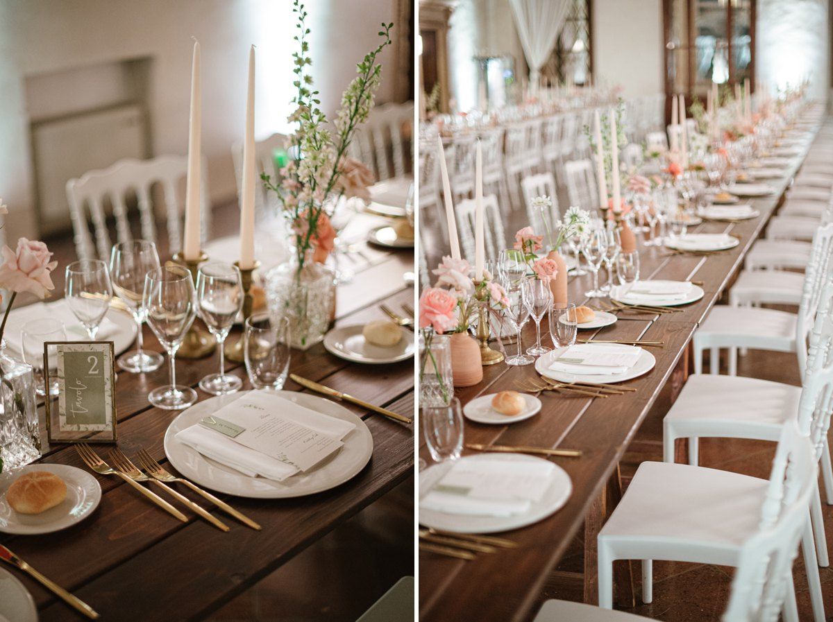 Elegant wedding table setting with white chairs and floral centerpieces.