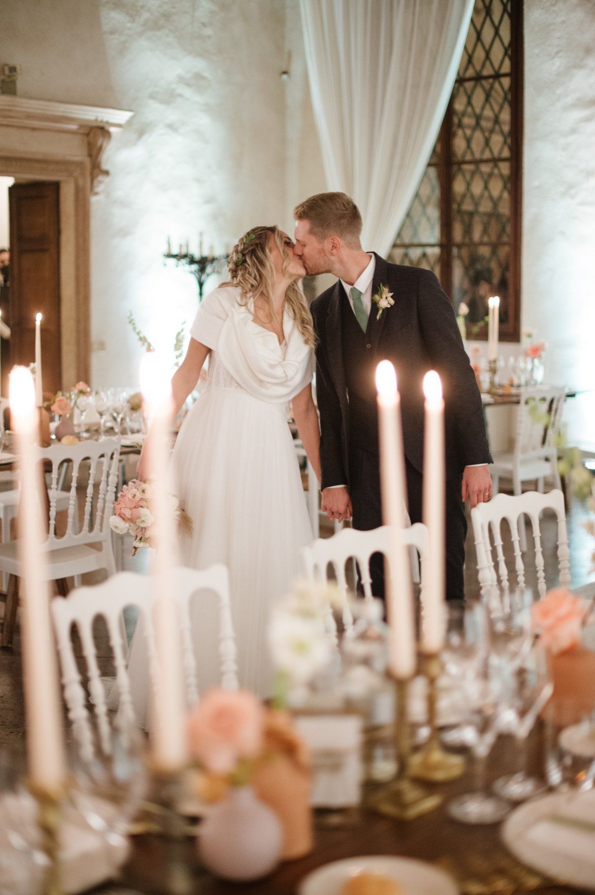 Romantic candlelit moment at elegant wedding reception with table settings.