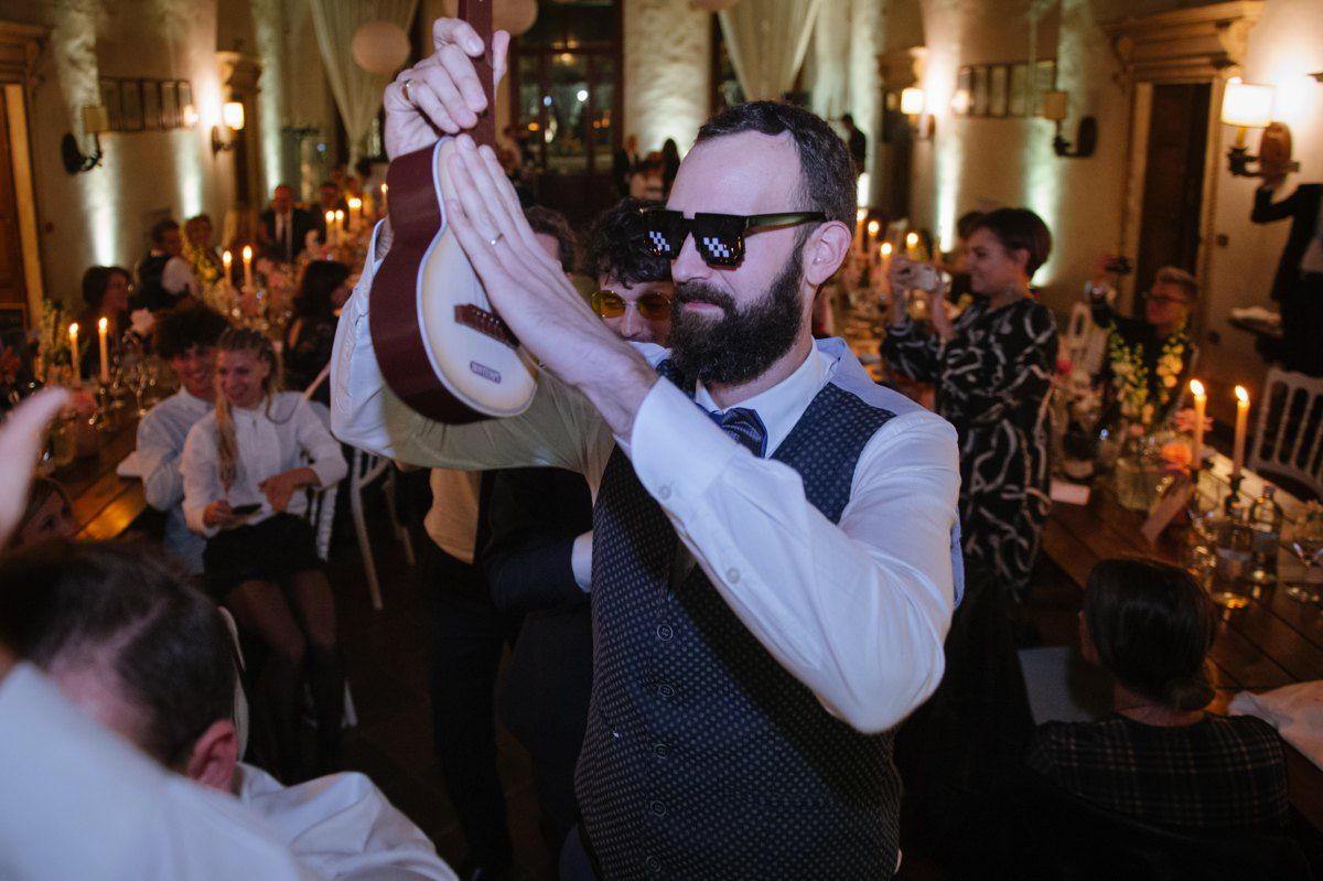 Wedding reception guest dancing enthusiastically at evening celebration.
