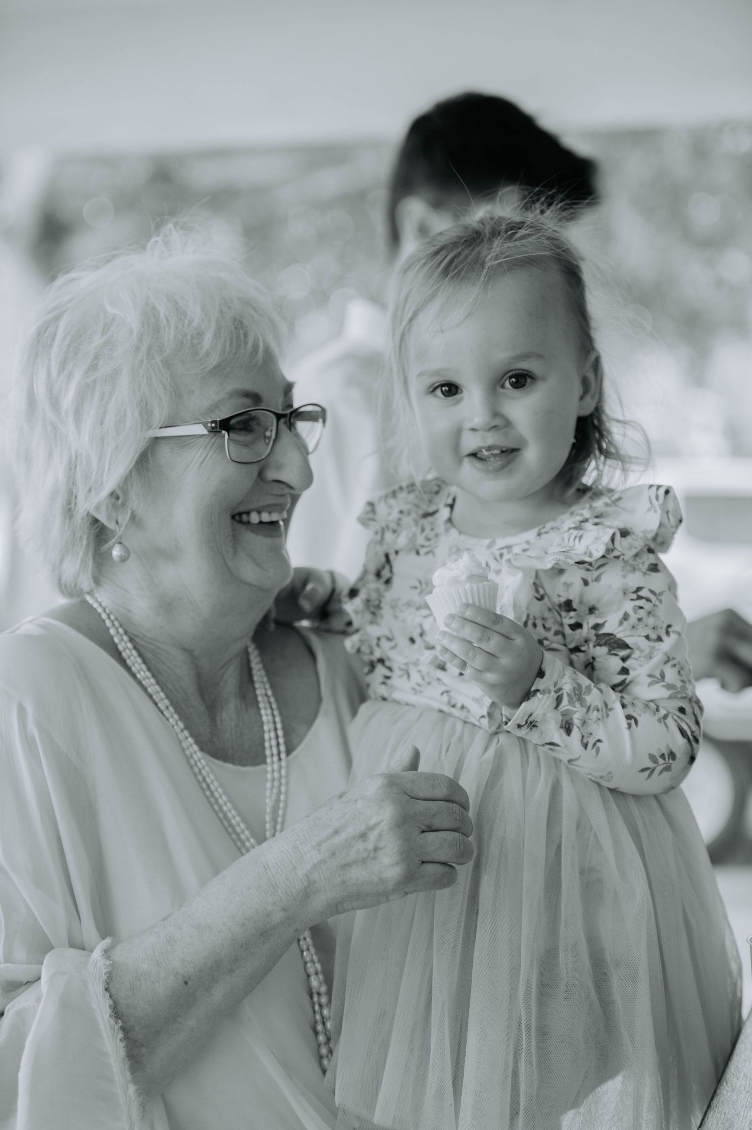 A black and white portrait of two people sharing a joyful moment.