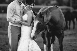 A couple poses with their horse during their rustic wedding photoshoot.